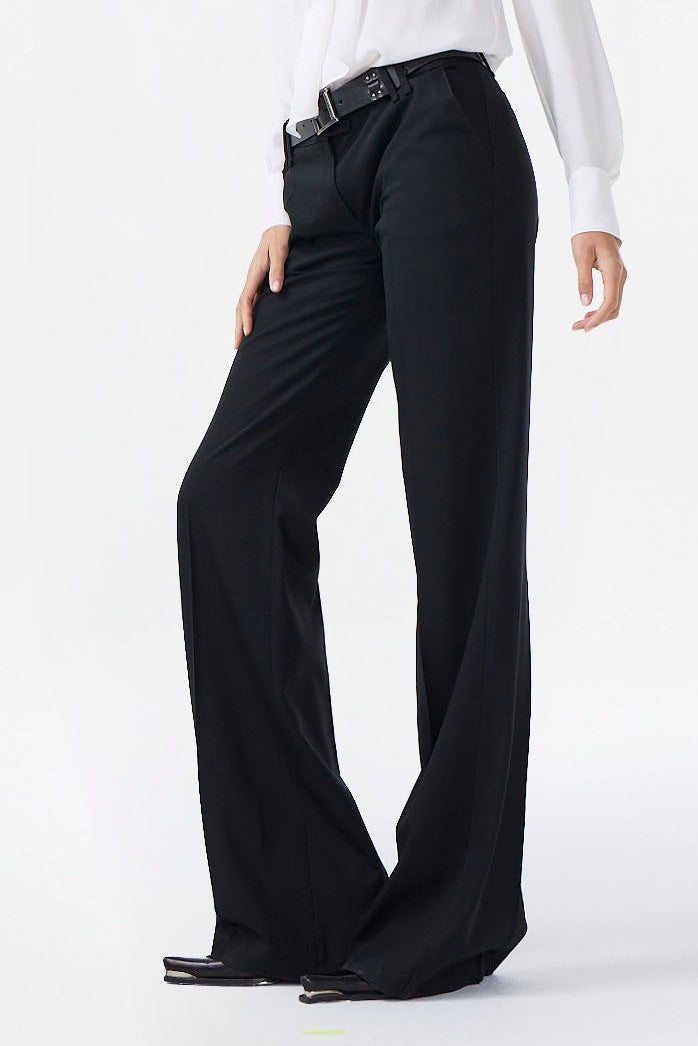 Woman wearing a white blouse and black pants on a white background