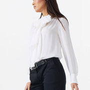 Woman wearing a white blouse and black pants on a white background