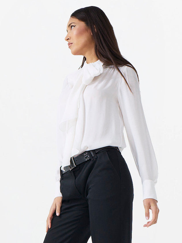 Woman wearing a white blouse and black pants on a white background