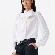Woman wearing a white blouse and black pants on a white background
