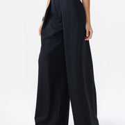 Woman wearing a black sleeveless jumpsuit on a white background