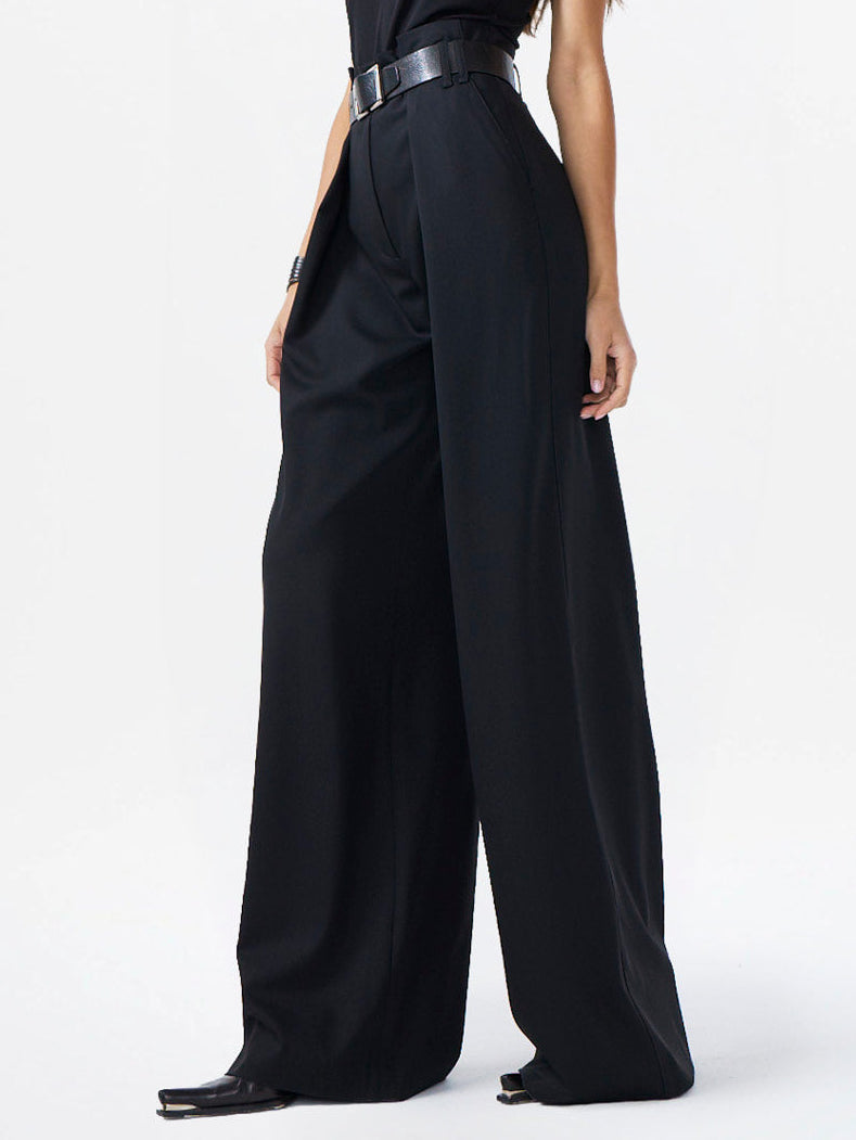 Woman wearing a black sleeveless jumpsuit on a white background